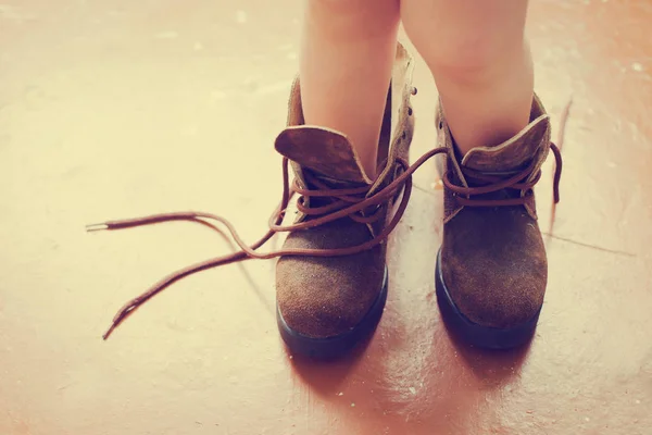 cropped image of little child wearing mothers shoes