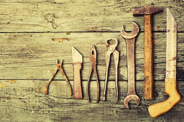 ahşap bir masa üzerinde eski paslı el araçlar kümesi