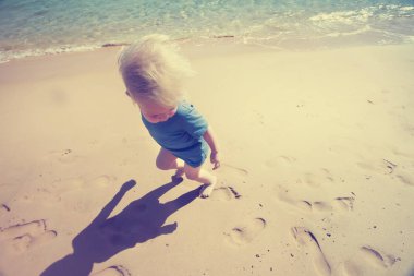 Yaz resort kumlu plajda çalışan mutlu yürümeye başlayan çocuk
