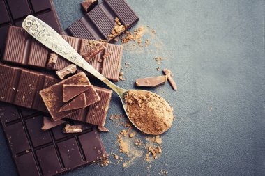 Gri zemin üzerine kaşıkla kırık çikolata