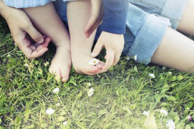 Anne ve oğlu çimenlerin üzerinde otururken doğanın keyfini görüntü kırpılmış