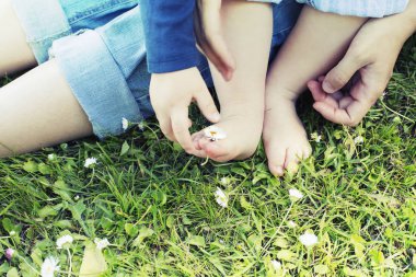 Anne ve oğlu çimenlerin üzerinde otururken doğanın keyfini görüntü kırpılmış