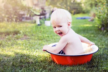 Havza yaz çayır üzerinde oynarken mutlu yürümeye başlayan çocuk Bahçe çim