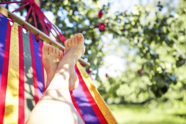 Erkek bacakları yeşil bahçesinde hamak döşeme 