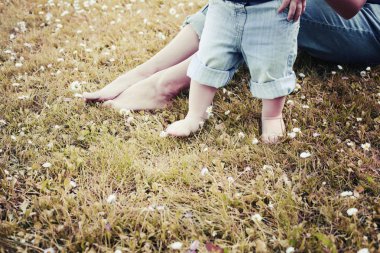 Anne ve oğlu çimenlerin üzerinde otururken doğanın keyfini görüntü kırpılmış