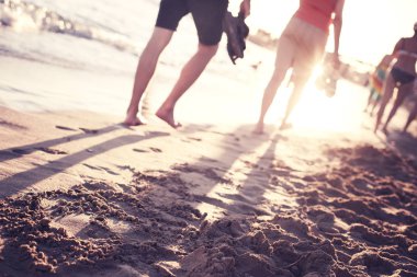 günbatımı bulanık kum üzerinde yürüyen insanlar ile plaj sahne