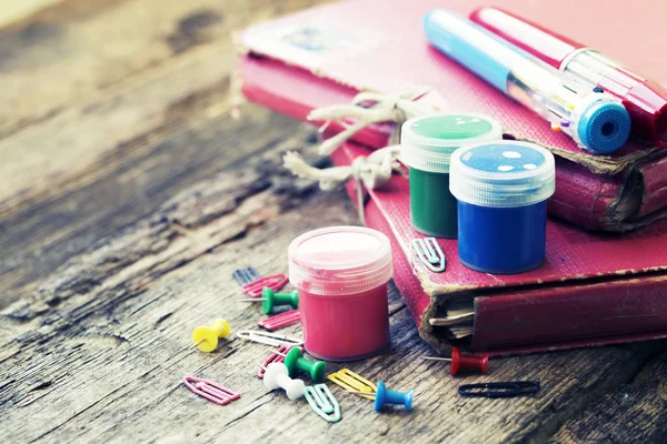 various colored drawing items with clips and holders on rustic wooden background