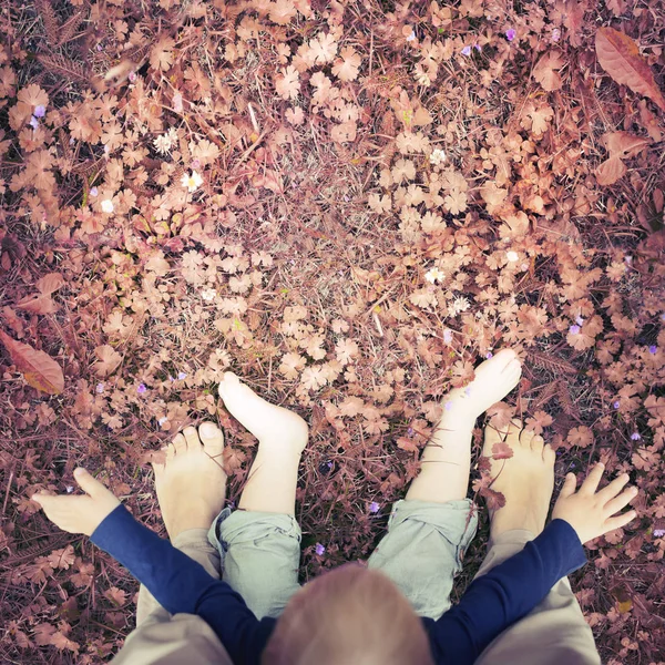 low section view of mother and son feet on grass