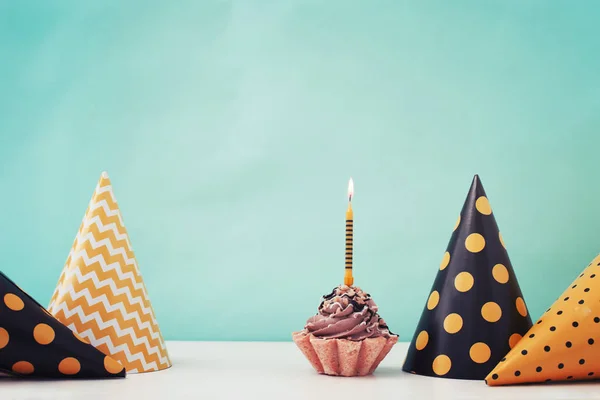 Birthday cake with candle and cone hats in vintage color, copy space