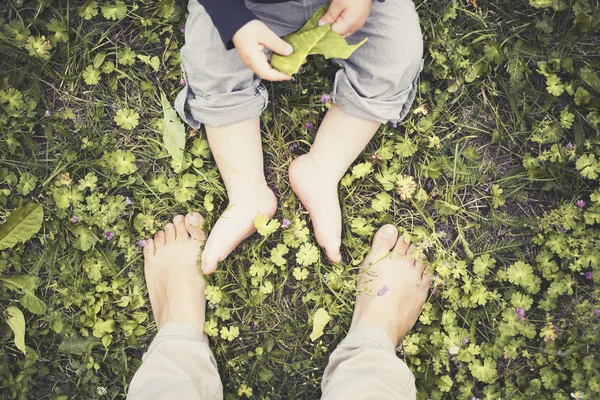 low section view of mother and son feet on grass