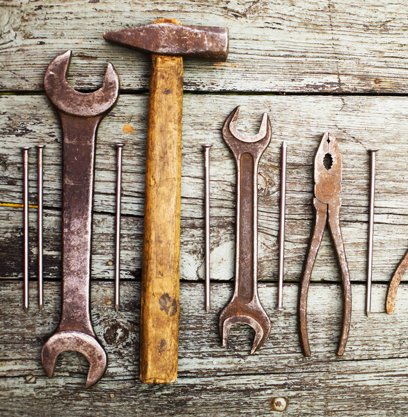 set of old rusty hand tools on a wooden table