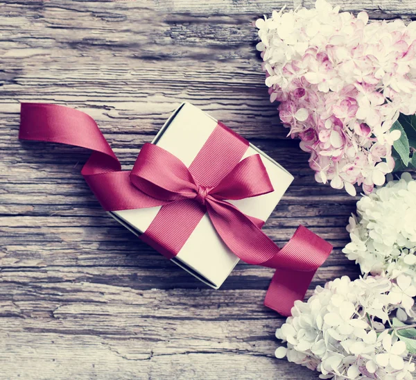 Weihnachtsgrußkarte Mit Lila Blumen Und Geschenkschachtel Auf Holzbrett — Stockfoto