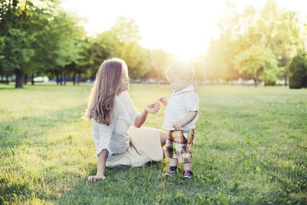 Счастливая Женщина Маленьким Сыном Отдыхает Зеленой Траве Солнечном Парке — стоковое фото