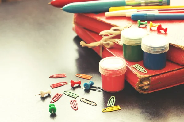 various colored drawing items with clips and holders on rustic wooden background