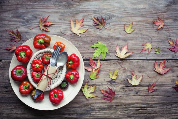 Färgglada Paprika Med Tallrik Och Bestick Trä Bakgrund — Stockfoto