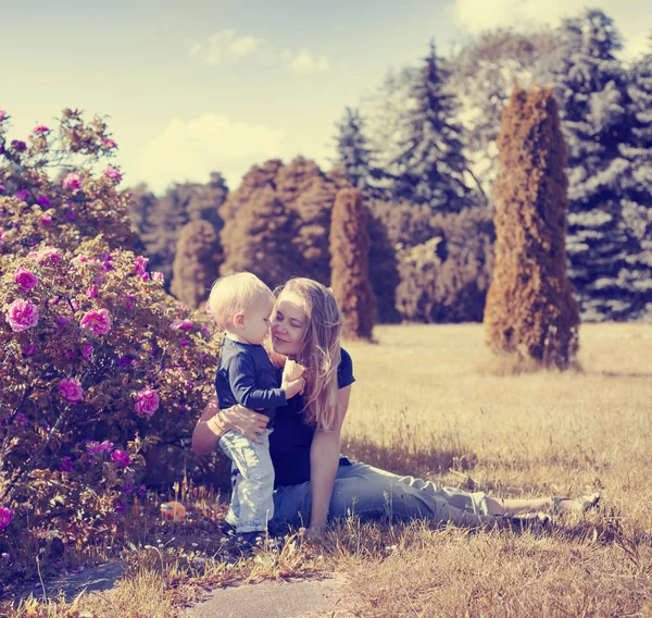 Mladá Žena Uvolňující Zelené Louce Malým Synem Sunny Park — Stock fotografie