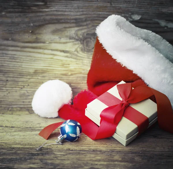明亮的摆设和圣诞老人红帽与礼品盒 — 图库照片