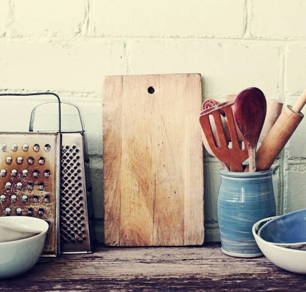 在白色墙壁背景的木桌上的不同厨具 — 图库照片
