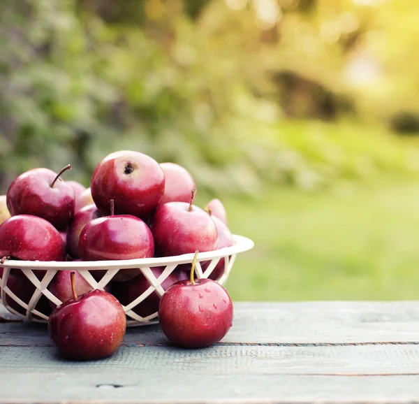 Ολόκληρα Κόκκινα Μήλα Στο Καλάθι Στο Ξύλινο Τραπέζι Στον Κήπο — Φωτογραφία Αρχείου