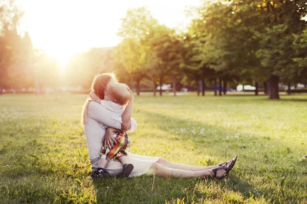 Felice Madre Che Abbraccia Piccolo Figlio Sul Prato Nel Parco — Foto Stock