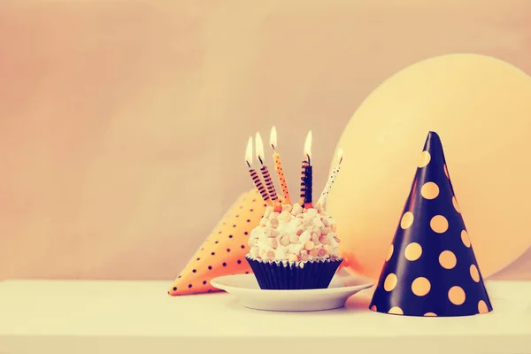 Birthday cake with candles and cone hats in vintage color, copy space