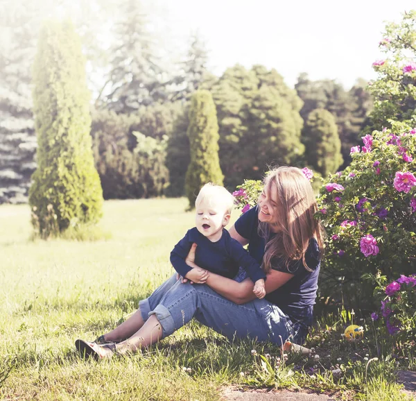 Šťastný Matka Relaxační Zelené Trávě Malým Synem Sunny Park — Stock fotografie