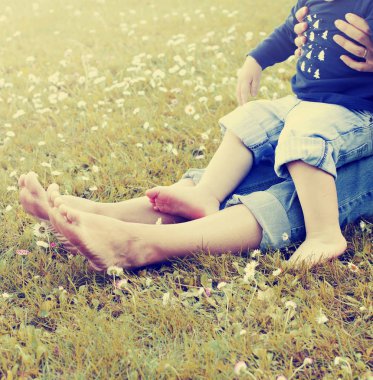 Anne ve oğlunun ayak yeşil çim üzerinde