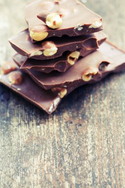 Ahşap arka plan üzerinde fındık ile kırık çikolata