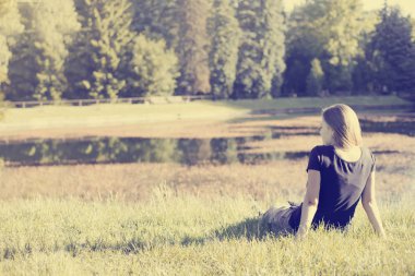 Dikiz doğa, çimlerin üzerine oturan kadın
