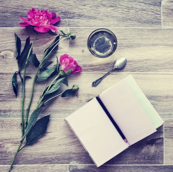 木製の背景の空のノートと美しいピンクの牡丹の花 — ストック写真