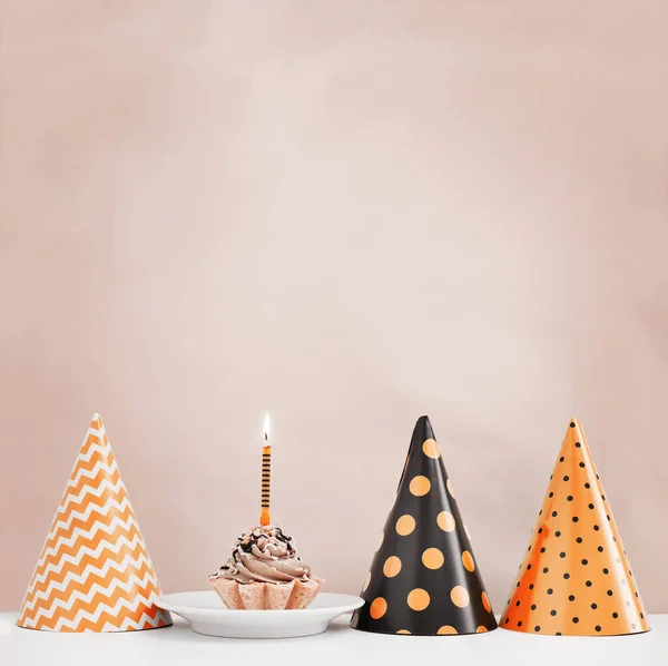 Birthday cake with candle and cone hats in vintage color, copy space