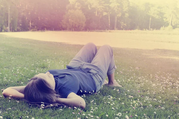 妇女躺在草地上与雏菊花 — 图库照片