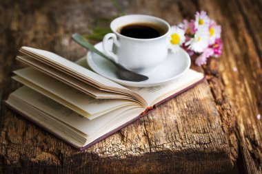 kahve fincanı çiçek ve ahşap masa kitap closeup görünümü