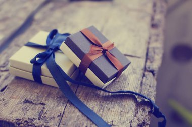 Colorful gift boxes with ribbons on wooden background