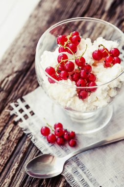 kırmızı meyveler ve ahşap masa kaşık ile cam kapta beyaz dondurma