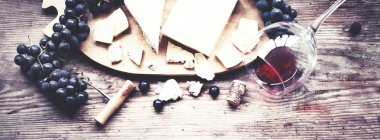 üzüm, peynir ve şarap ahşap arka plan üzerinde lezzetli bileşimi