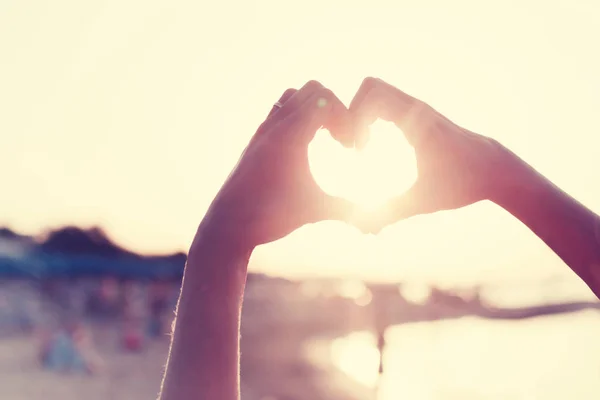 Manos Femeninas Mostrando Signo Del Corazón Contra Luz Del Sol — Foto de Stock