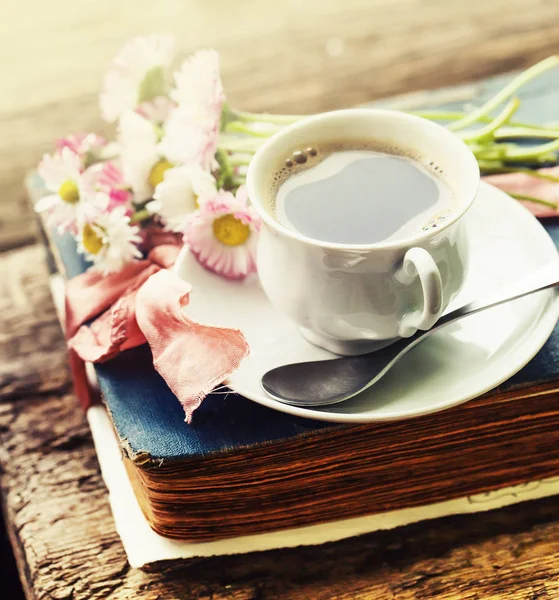 咖啡杯的特写镜头与鲜花和书在木桌上 — 图库照片