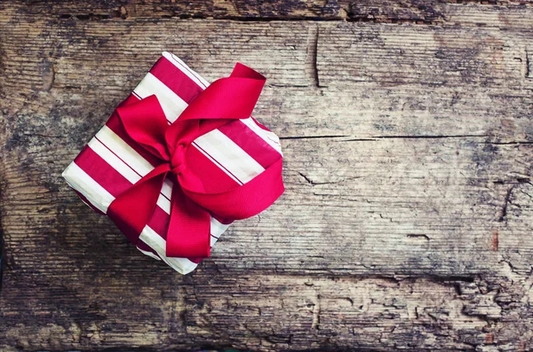 Προβολή Closeup Της Τυλιγμένο Δώρο Χριστουγέννων Κόκκινη Κορδέλα Φόντο Ξύλινη — Φωτογραφία Αρχείου