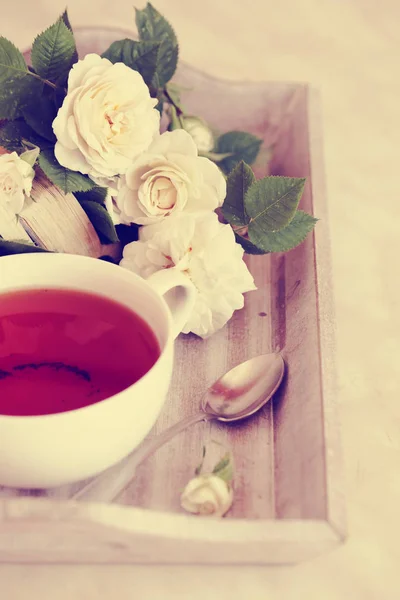 白い花とヴィンテージの色で木の板にスプーンを入れた紅茶 — ストック写真