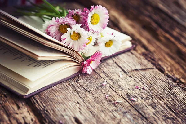 在木桌上的质朴的花朵花束打开书 — 图库照片