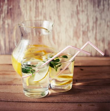 nane ile taze ev yapımı limonata sürahi gözlük ile ahşap arka plan üzerinde bırakır.