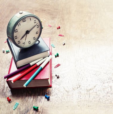 kitap ve ahşap masa saati çok renkli işaretleyicileri