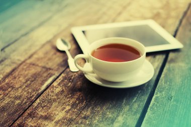 çay ve dijital tablet ahşap masanın üzerinde yatan closeup görünümü