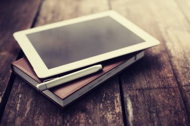 closeup görünümünü dijital tablet ve ahşap masanın üzerinde yatan pikap iğnesi