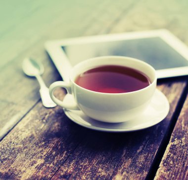 çay ve dijital tablet ahşap masanın üzerinde yatan closeup görünümü