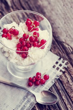 kırmızı meyveler ve ahşap masa kaşık ile cam kapta beyaz dondurma