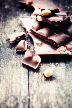 Ahşap arka plan üzerinde fındık ile kırık çikolata