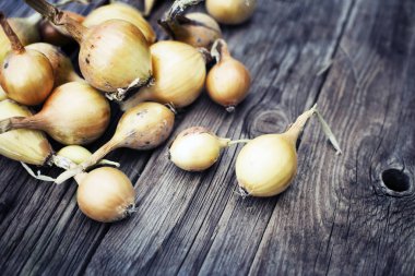 Ahşap masa üzerinde soyulmamış soğan yığını