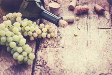 şişe beyaz şarap, üzüm ve mantarlar ahşap tablo